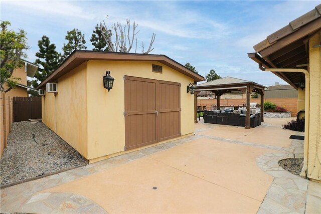 10629 El Este Ave, Fountain Valley, CA 92708 - view of shed featuring a fenced backyard, a wall mounted AC, a gazebo, and an outdoor living space