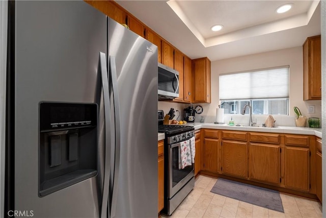 27191 Ryan Dr, Laguna Niguel, CA 92677 - kitchen with a sink, brown cabinetry, stainless steel appliances, a raised ceiling, and recessed lighting