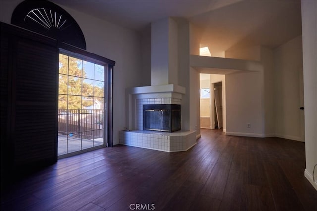 30069 Milano Rd, Temecula, CA 92591 - unfurnished living room with hardwood / wood-style floors, a tiled fireplace, and baseboards