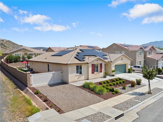 view of front facade with a gate, driveway, stucco siding, fence, and an attached garage
