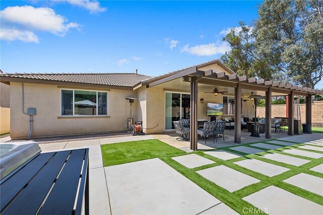 back of house with a ceiling fan, fence, stucco siding, a patio, and a tile roof