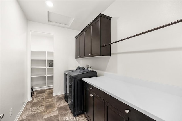 washroom with cabinet space, separate washer and dryer, light stone finish flooring, baseboards, and attic access