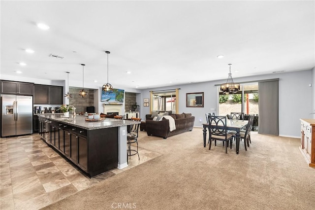 kitchen with stainless steel fridge with ice dispenser, healthy amount of natural light, recessed lighting, a chandelier, and dark brown cabinetry