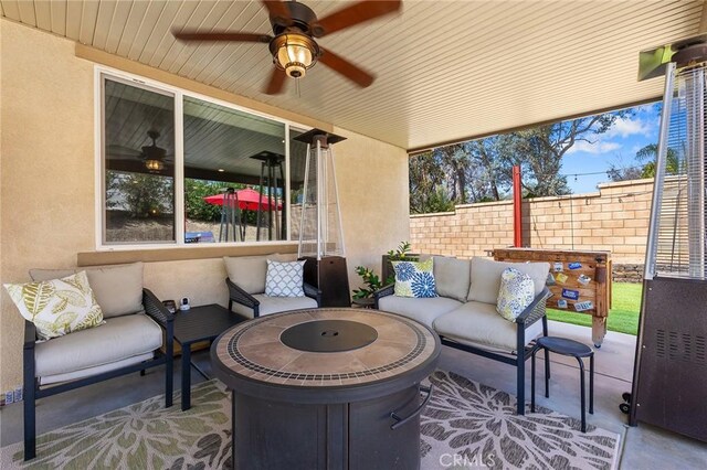 view of patio / terrace featuring an outdoor living space, fence, and a ceiling fan