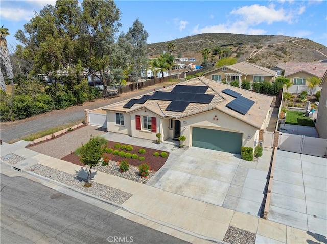 view of front of home with a gate, an attached garage, fence, stucco siding, and a mountain view