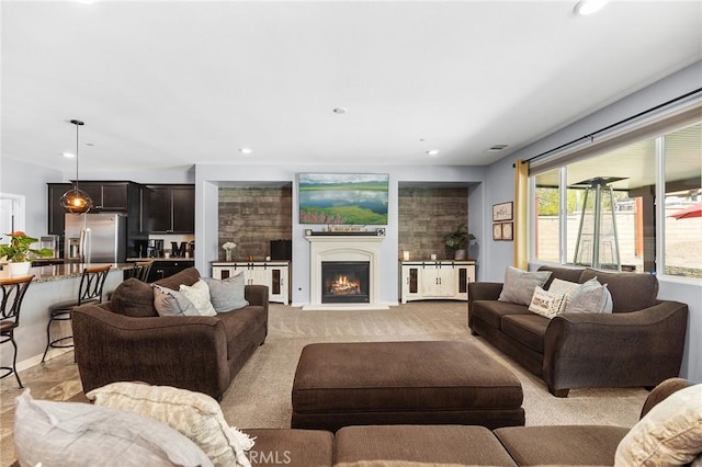 living area featuring a warm lit fireplace and recessed lighting