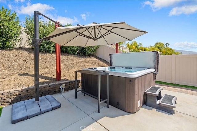 view of patio with a hot tub and a fenced backyard