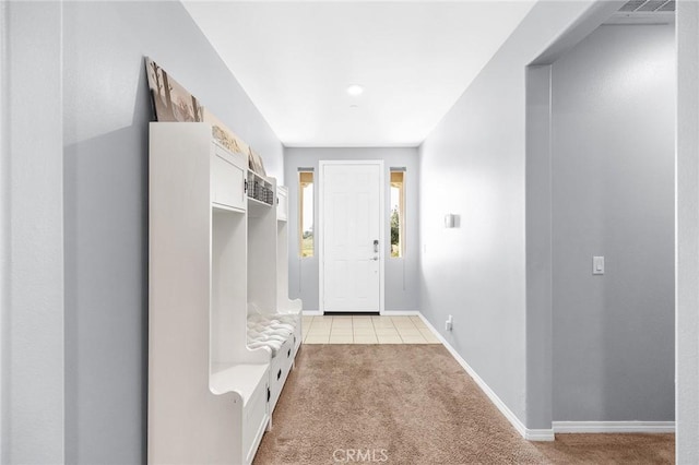 mudroom featuring light colored carpet, baseboards, and light tile patterned floors