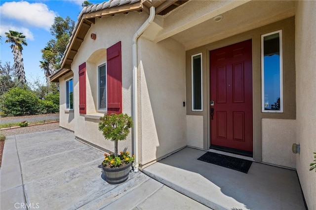 entrance to property featuring stucco siding