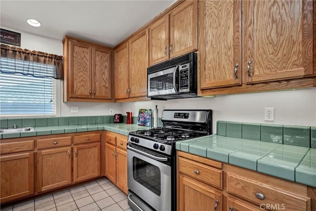 17126 Squirrelhill Rd, Hidden Valley Lake, CA 95467 - kitchen featuring light tile patterned floors, recessed lighting, brown cabinets, and appliances with stainless steel finishes