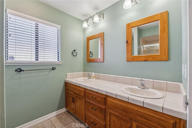 689 E Pintail Cir, Fresno, CA 93730 - bathroom with a sink, double vanity, baseboards, and tile patterned floors