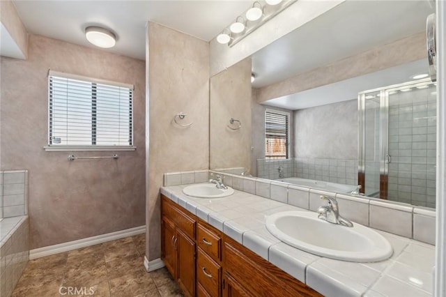 689 E Pintail Cir, Fresno, CA 93730 - bathroom featuring baseboards, a garden tub, double vanity, and a sink