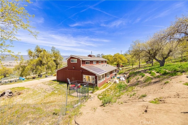 back of house featuring an outbuilding, a barn, and fence