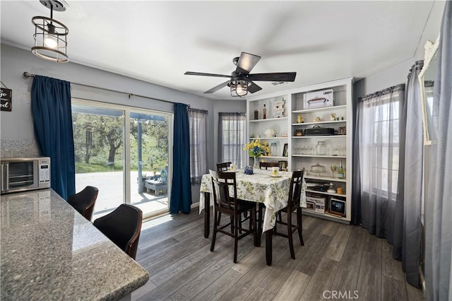 dining area featuring a toaster, ceiling fan, and dark wood-style flooring