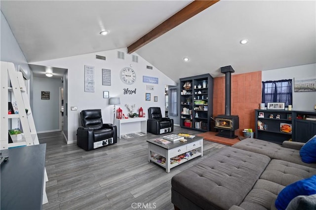 living area with lofted ceiling with beams, baseboards, recessed lighting, wood finished floors, and a wood stove