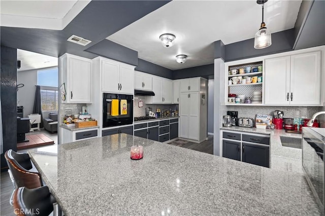 kitchen with white cabinets, oven, a sink, light stone countertops, and tasteful backsplash