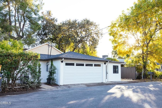 garage with driveway and fence