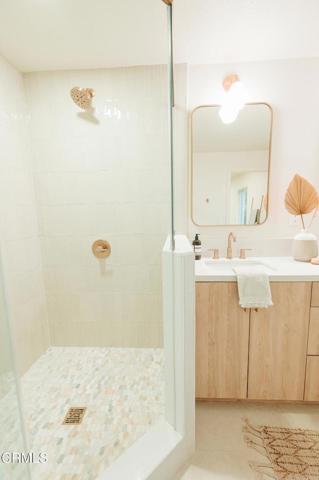 bathroom with tiled shower and vanity
