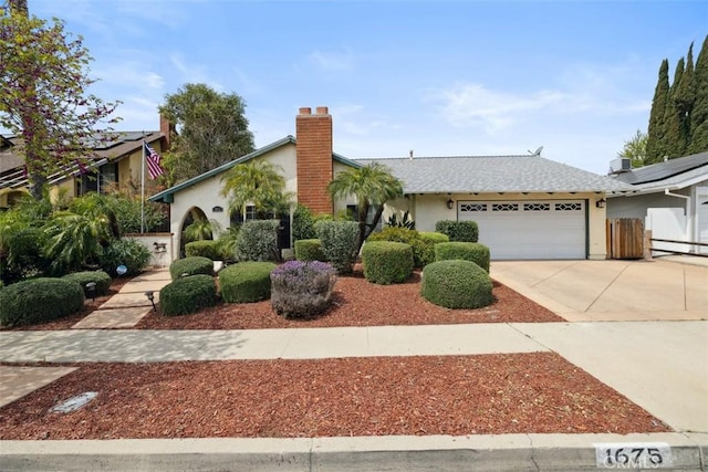 1675 Bridget Ave, Simi Valley, CA 93065 - view of front of house with an attached garage, stucco siding, driveway, and a chimney