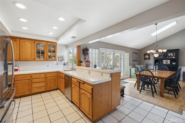 1675 Bridget Ave, Simi Valley, CA 93065 - kitchen with a peninsula, a chandelier, stainless steel appliances, brown cabinets, and glass insert cabinets