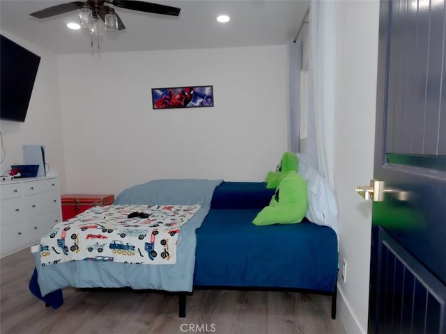 bedroom with a ceiling fan, wood finished floors, and recessed lighting