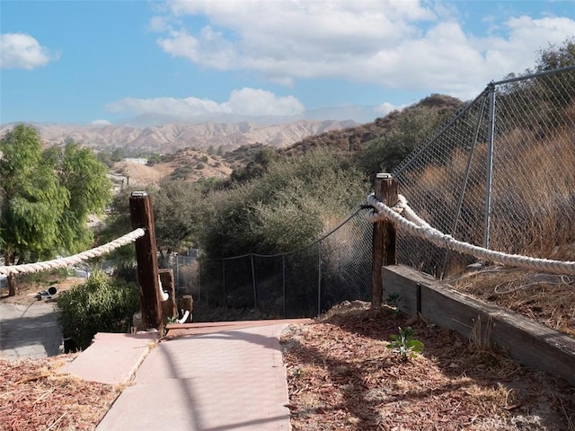 view of gate with fence and a mountain view