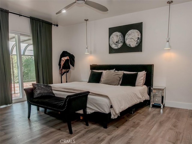 bedroom featuring wood finished floors, access to exterior, baseboards, and ceiling fan