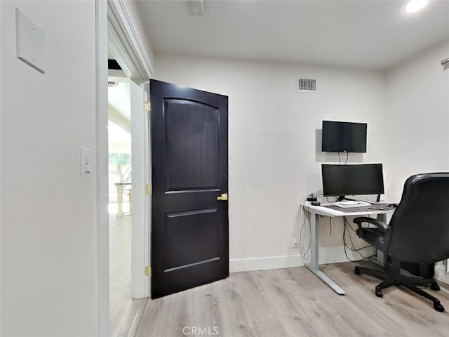 office space featuring baseboards, wood finished floors, and visible vents