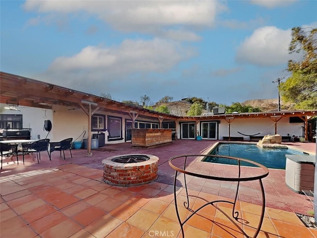 pool with a patio area, cooling unit, and an outdoor fire pit