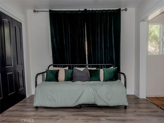 bedroom featuring baseboards and wood finished floors