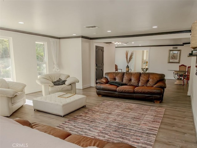 living room featuring crown molding, wood finished floors, baseboards, visible vents, and recessed lighting