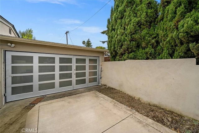 view of patio / terrace with fence and an outbuilding