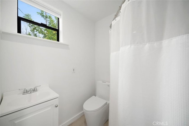 full bath featuring vanity, baseboards, and toilet