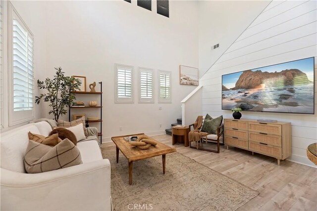 9 Adelfa St, Rancho Mission Viejo, CA 92694 - living room with stairway, visible vents, a towering ceiling, and light wood finished floors