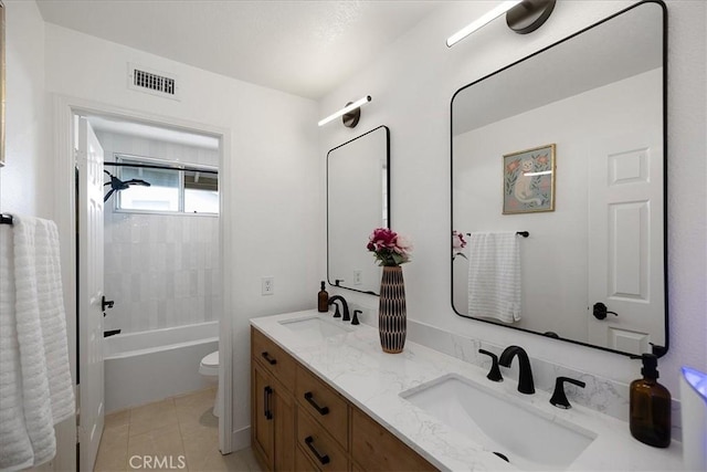 bathroom with double vanity, visible vents, toilet, and a sink