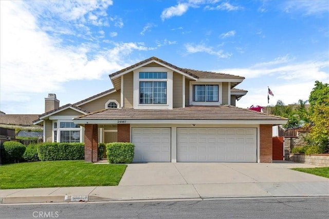 traditional-style home with concrete driveway, an attached garage, a tile roof, and a front yard