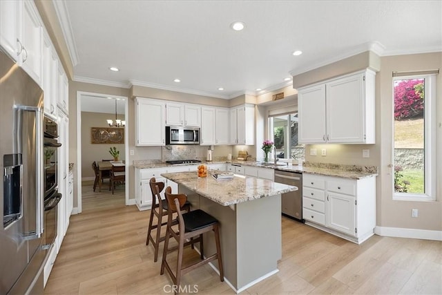 kitchen with white cabinets, appliances with stainless steel finishes, and light wood finished floors