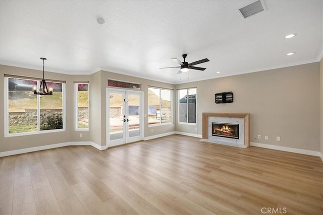 unfurnished living room with visible vents, french doors, baseboards, and a healthy amount of sunlight