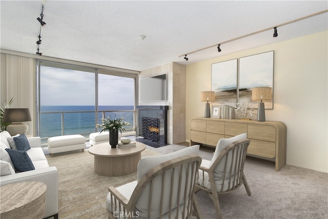 615 Esplanade Unit 302, Redondo Beach, CA 90277 - living area featuring track lighting, a water view, a fireplace with flush hearth, floor to ceiling windows, and a textured ceiling