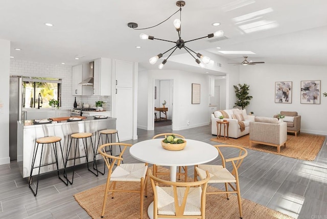 dining room featuring baseboards, recessed lighting, wood finish floors, ceiling fan, and a chandelier