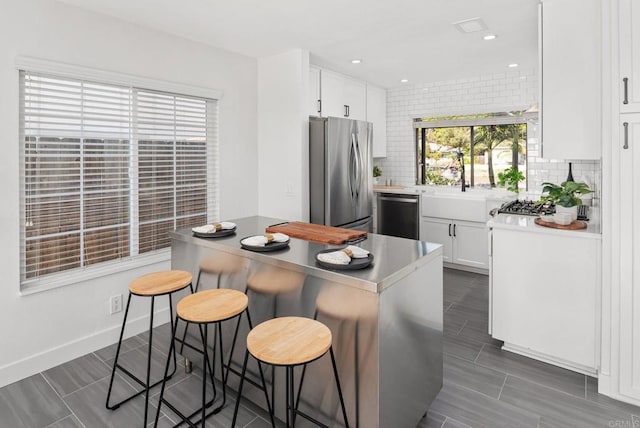 kitchen with freestanding refrigerator, dishwasher, decorative backsplash, white cabinets, and recessed lighting