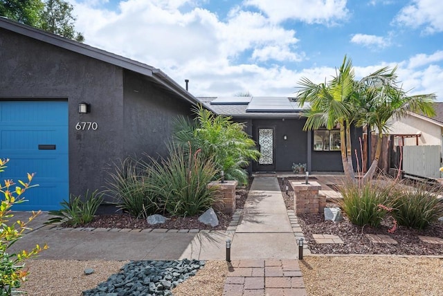 6770 Amberly St, San Diego, CA 92120 - view of front of home with roof mounted solar panels, stucco siding, and a garage