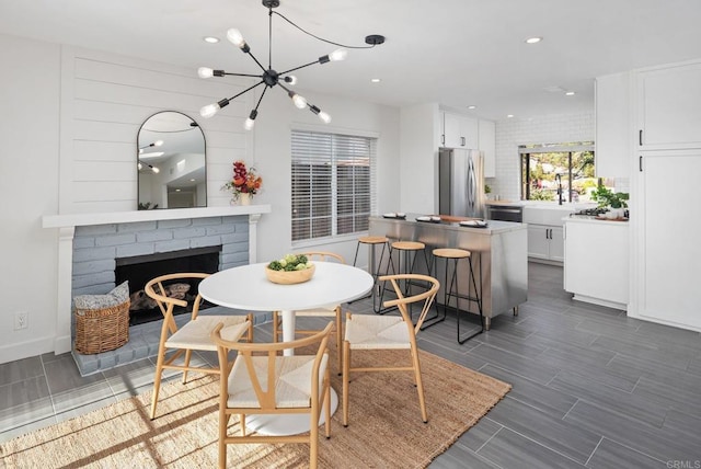 6770 Amberly St, San Diego, CA 92120 - dining area with recessed lighting, a chandelier, wood tiled floors, and a brick fireplace