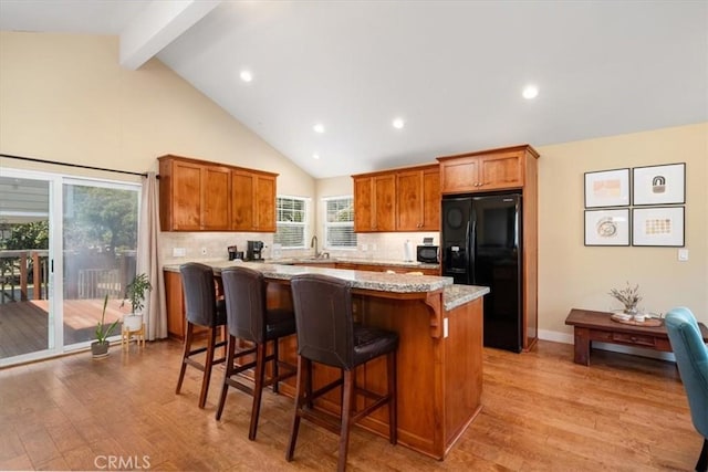2103 Price St, San Luis Obispo, CA 93401 - kitchen featuring black fridge, beam ceiling, a kitchen island, and light wood-type flooring