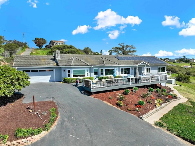 4710 Sleeping Indian Rd, Fallbrook, CA 92028 - ranch-style home featuring an attached garage, aphalt driveway, roof mounted solar panels, and a deck