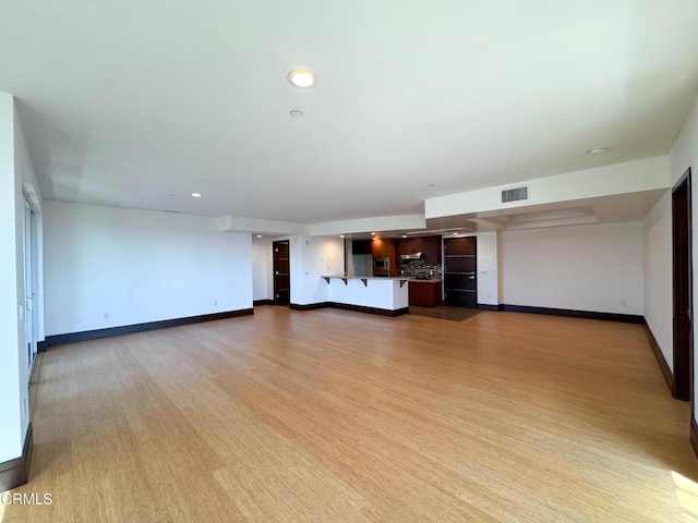 unfurnished living room with visible vents, baseboards, recessed lighting, and light wood-style floors