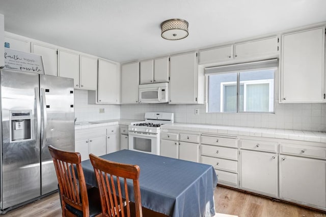 376163 Swift Ave, San Diego, CA 92104 - kitchen with white appliances, tile countertops, light wood-type flooring, and white cabinets