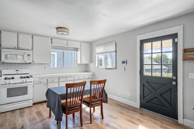 376163 Swift Ave, San Diego, CA 92104 - kitchen featuring white appliances, tasteful backsplash, light wood-style floors, and healthy amount of natural light