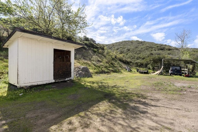 view of shed with a carport and a mountain view