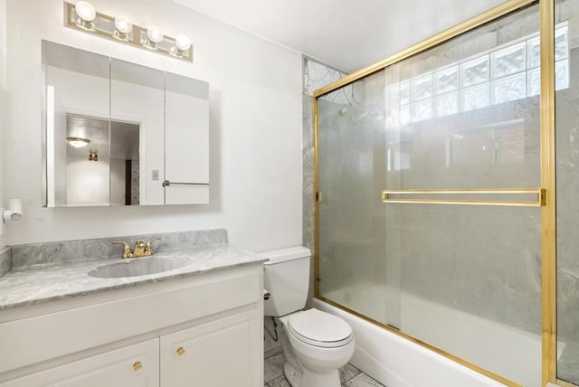 full bathroom with enclosed tub / shower combo, toilet, and vanity